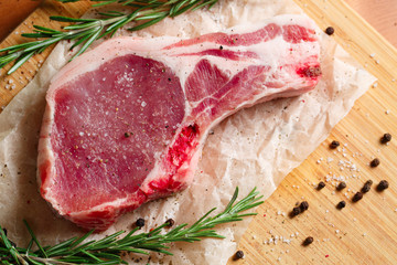 Pieces of crude meat with rosemary and spices