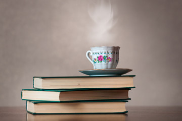 Стопка книг и чашка гопячего чая