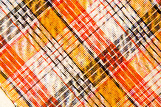 Fototapeta The texture of white checkered, orange, red, black cotton fabric