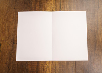 Bifold white template paper on wood texture