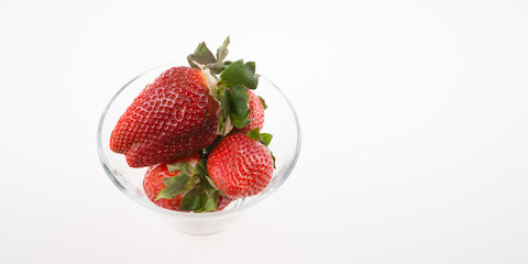 Fresh strawberries in a glass bowl isolated