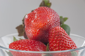 Fresh strawberries in a glass bowl isolated