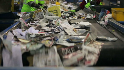 Workers sorting paper and plastic on a recycling belt - Powered by Adobe