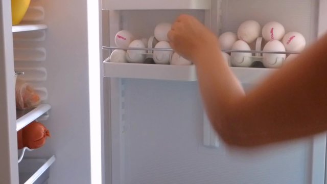 A woman lays in a fridge the chicken eggs