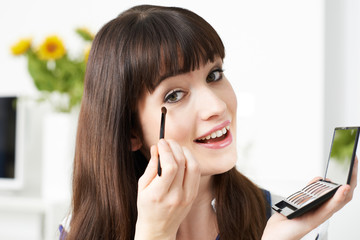 Young Woman Applying Eye Make Up At Home