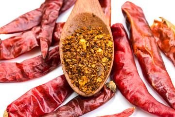 cayenne pepper on wood spoon and dry pepper on white