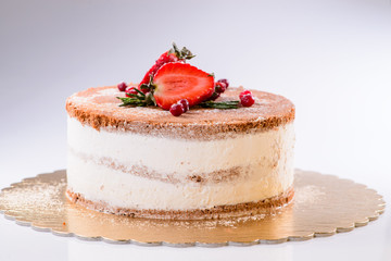 Cake with Cream, decorated with strawberries on a light backgrou