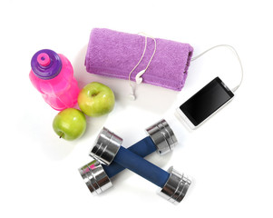 Fitness concept with a bottle of water, a towel, dumbbells, apples and a smartphone isolated