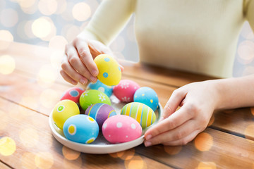 Fototapeta na wymiar close up of woman hands with colored easter eggs