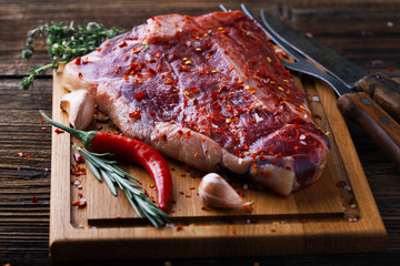 Raw fresh meat T-Bone Steak with herbs and spices and chilli pep