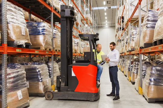 men with tablet pc and forklift at warehouse