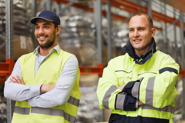 smiling men in reflective uniform at warehouse