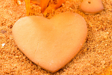 Fototapeta na wymiar closeup of Gingerbread in the form of heart on the sandy cake