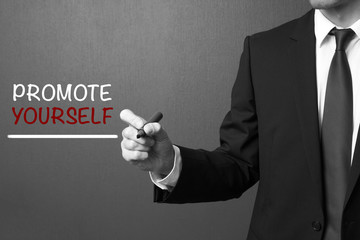 Business man writing: Promote yourself
