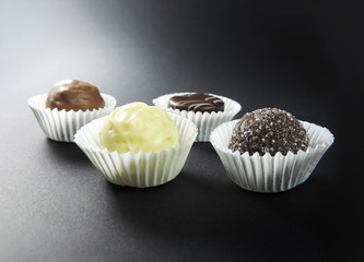Chocolates, isolated on black. Chocolate truffles, arrangement.