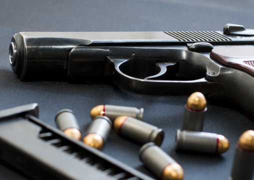 handgun with cartridge on the black background