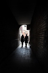 Couple holding hands in dark London alley street