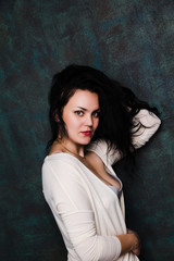Studio portrait of a sexy brunette in grey lingerie and white cardigan