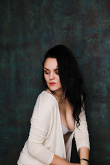 Fototapeta premium Studio portrait of a sexy brunette in grey lingerie and white cardigan