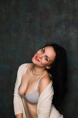 Studio portrait of a sexy brunette in grey lingerie and white cardigan