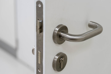 silver handle on white door