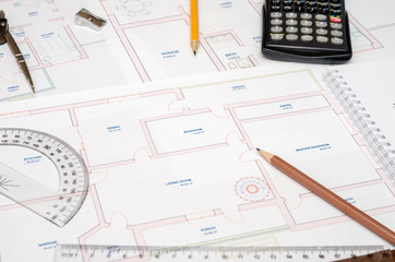 Architect's workspace with plan and pencil, calculator, ruler, compass