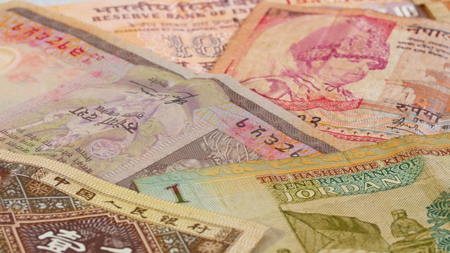 Different asian currency bank notes rotating and panning business background