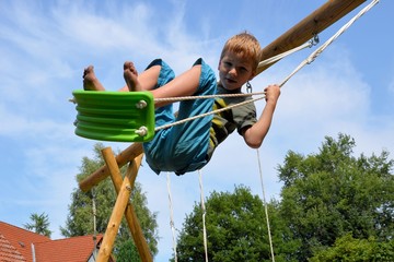 Kind schaukelt übermütig 