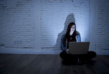 scared female teenager with computer laptop suffering cyberbullying and harassment being online...