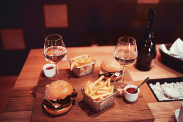 fast food set big hamburger and french fries with wine. shallow DOF