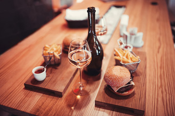 fast food set big hamburger and french fries with wine. shallow DOF