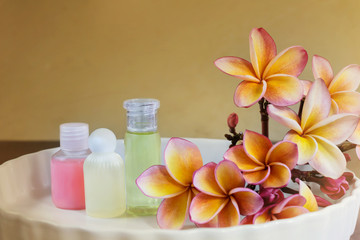 Fototapeta na wymiar Mini set of shampoo or shower bath on white plate with flowers b