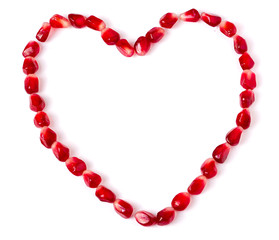 Heart symbol made from pomegranate seeds isolated on white background
