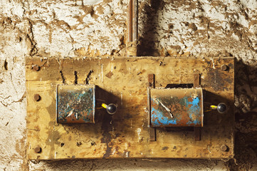 antique electric industrial switches in  old mud  wall