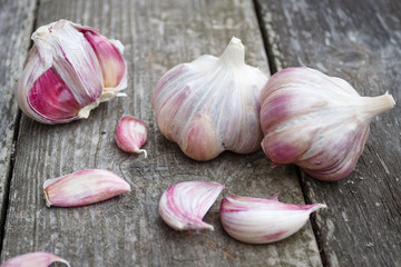 Organic garlic whole and cloves on the old wooden background..