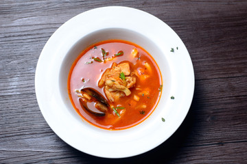 Delicious soup with mussels on black background