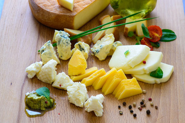 Various types of cheese laid out on a wooden Board