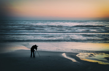 Naklejka premium Silhouette of the photographer on the seashore