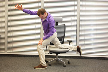 man exercising on chair in office, healthy lifestyle - profile view