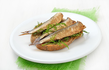 Sprats sandwiches on white plate