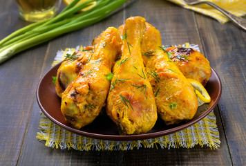 Roasted chicken drumsticks on wooden table