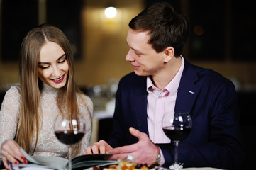 guy with a girl in a restaurant choose dishes from the menu