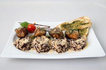 Bites of pork with white and black rice.