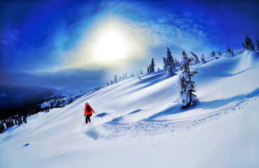 Fototapeta na wymiar Skier skiing downhill in high mountains against sunset