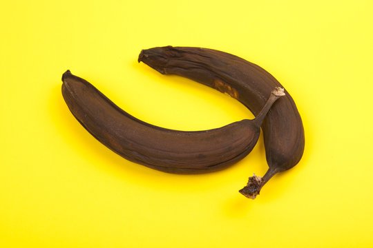 zwei verfaulte Bananen auf gelbem Hintergrund