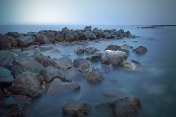 Stone shore of the ocean at sunset