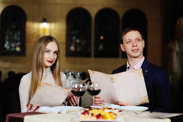 guy with a girl in a restaurant choose dishes from the menu