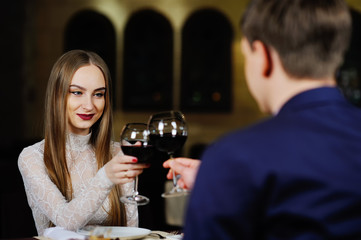 a man with a woman drinking red wine in a restaurant