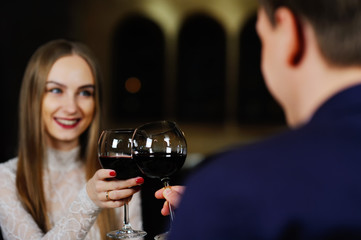 a man with a woman drinking red wine in a restaurant