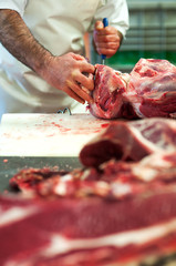 Butcher cutting up raw meat in a butchery
